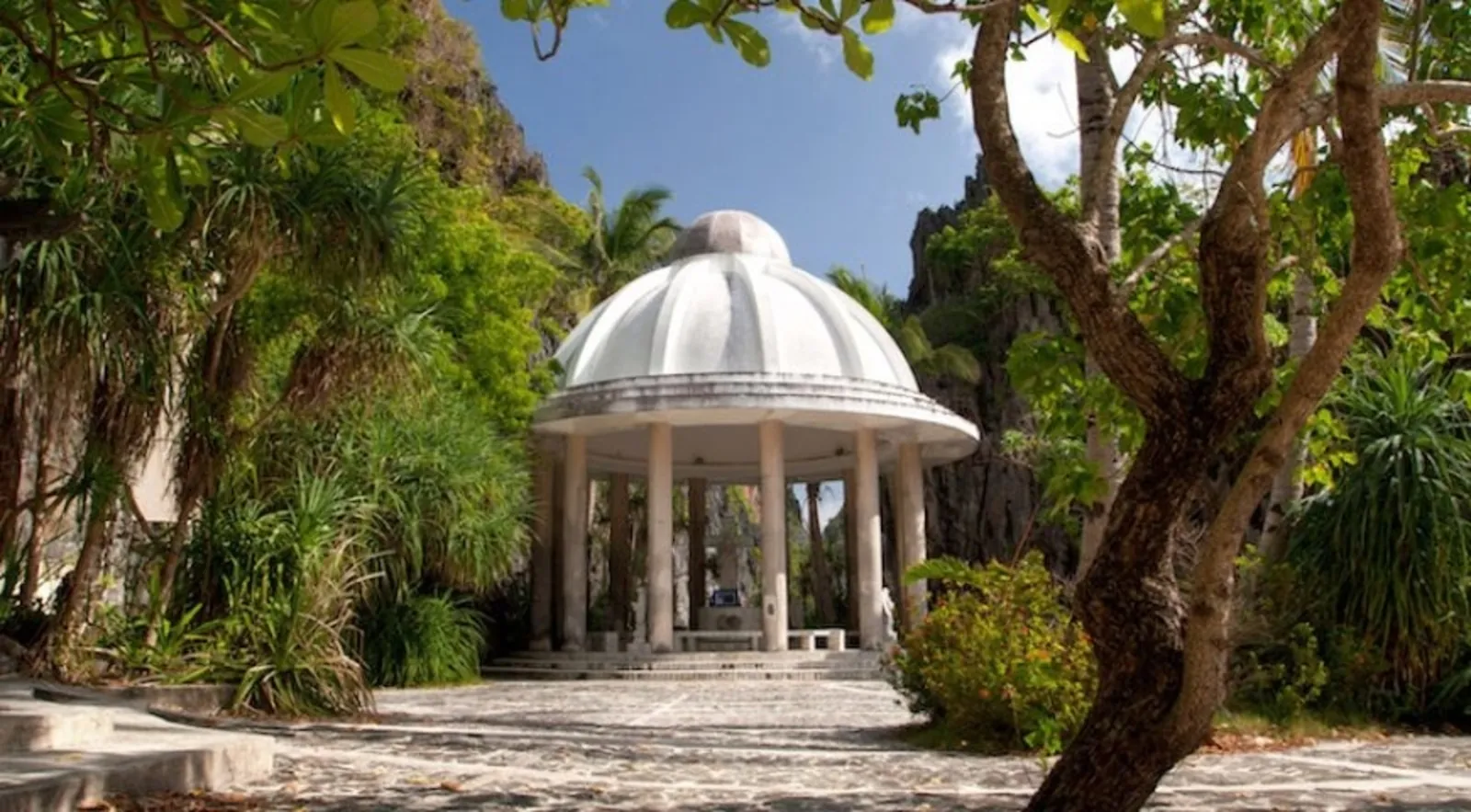 A white domed shrine among trees on an island