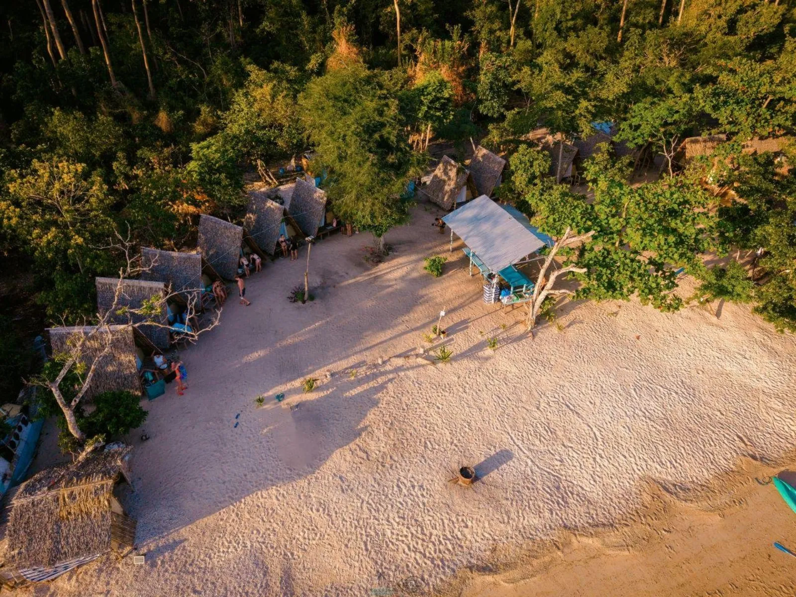 Aerial view of thatched native huts on a sandy island campsite
