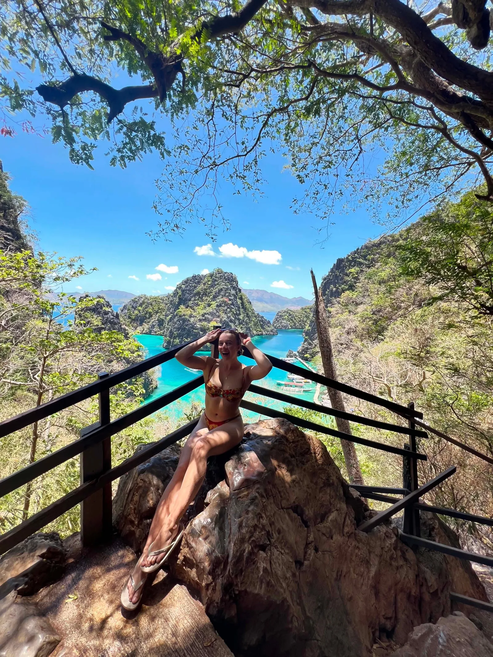 A traveller posing at a viewpoint above lagoons and limestone peaks