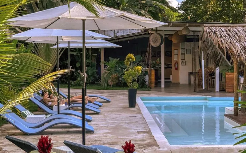 Pool, sun loungers and umbrellas in the garden of El Nido Moringa Resort
