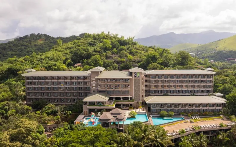 Zuri Resort's hotel wings and pools on a wooded hillside above Coron