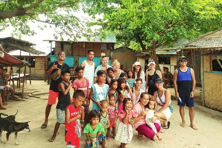 Travellers with children from a fishing village in front of their homes