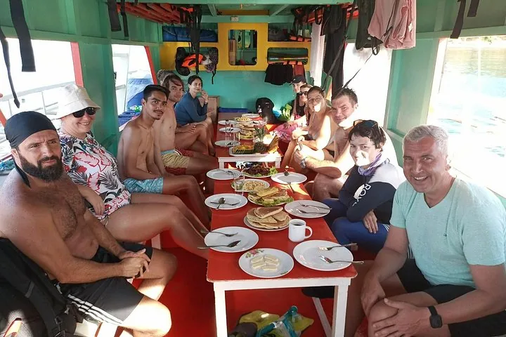 A small private group eating lunch at a table on board