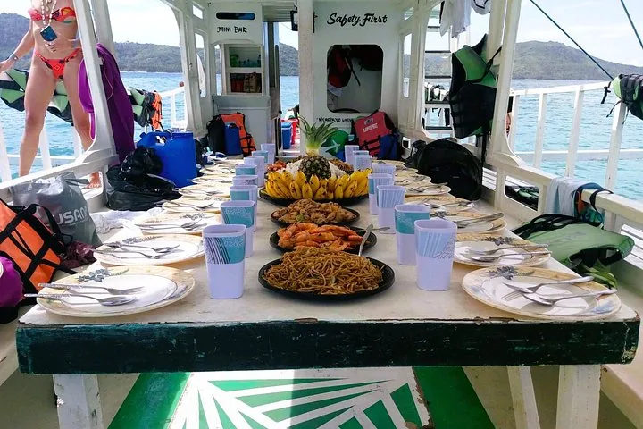 A long table set with lunch dishes on the deck of the expedition boat